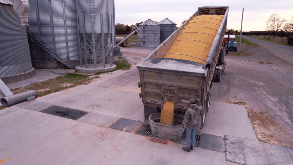 An employee unloads a truck at a feed mill.